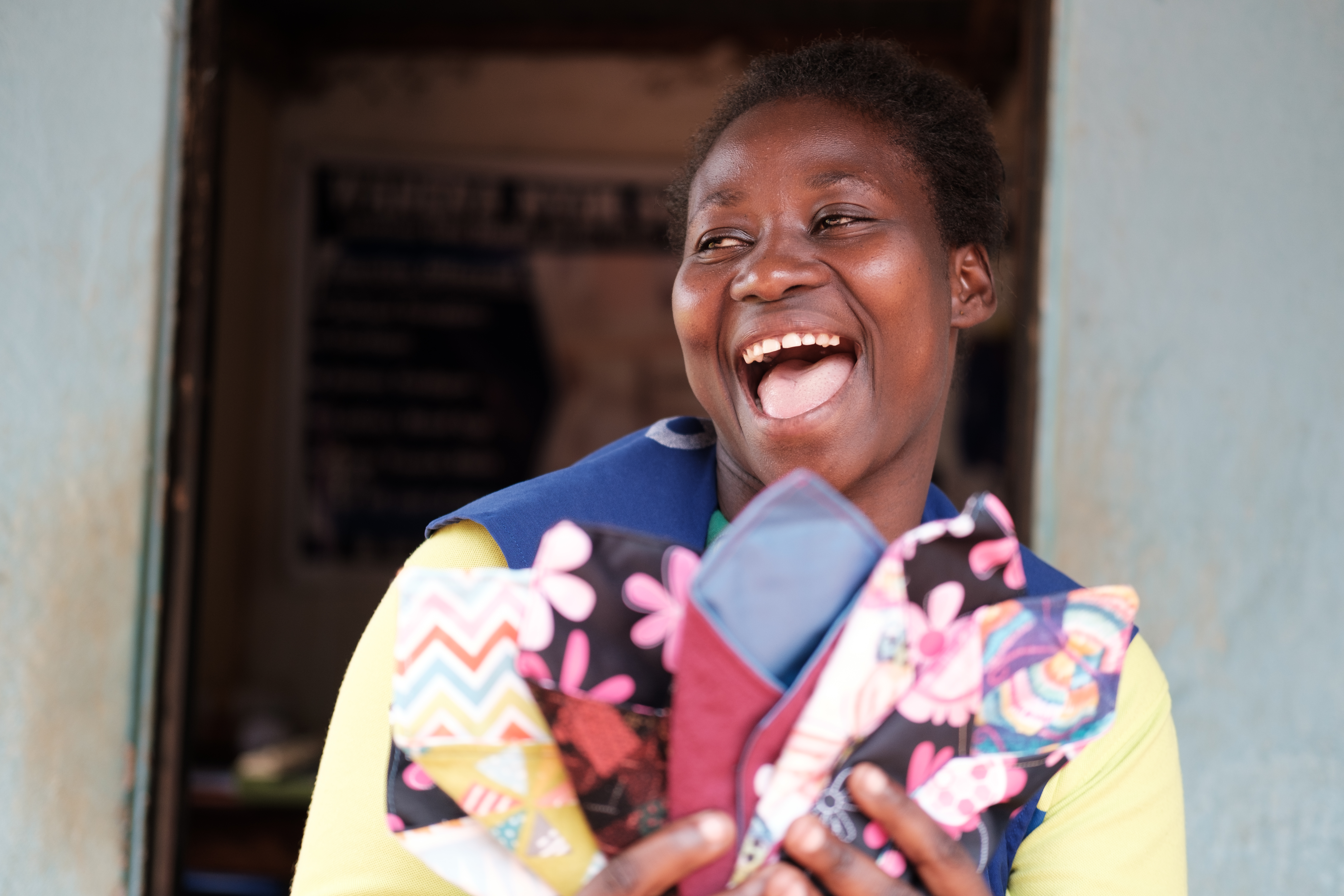 Miriam shows some of the reusable pads she now makes and sells to schools.